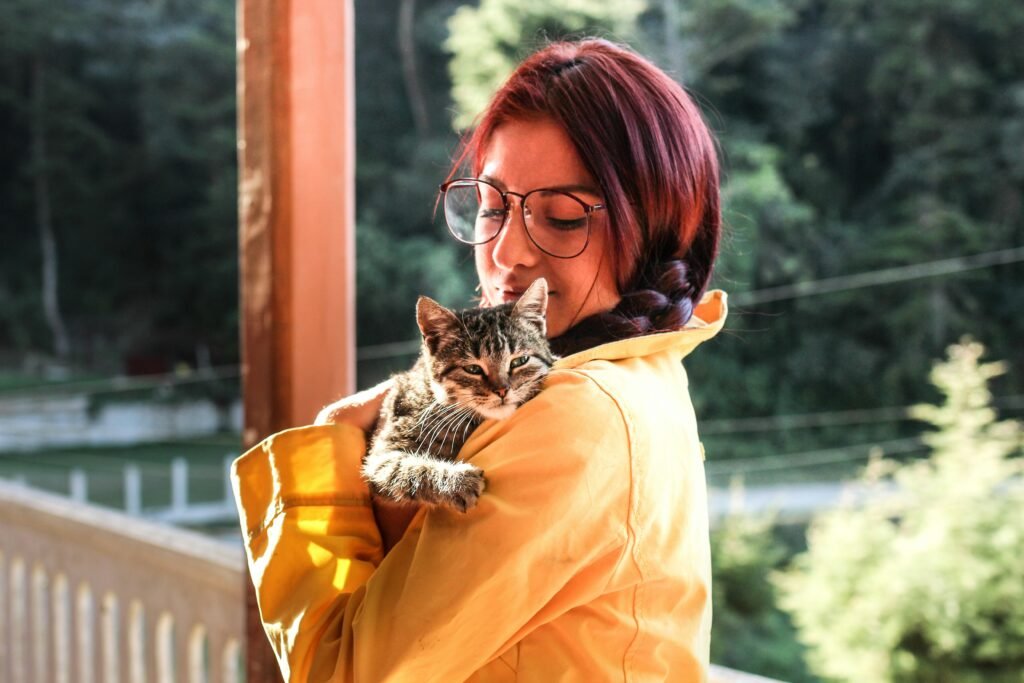 Woman carrying a cat on a porch